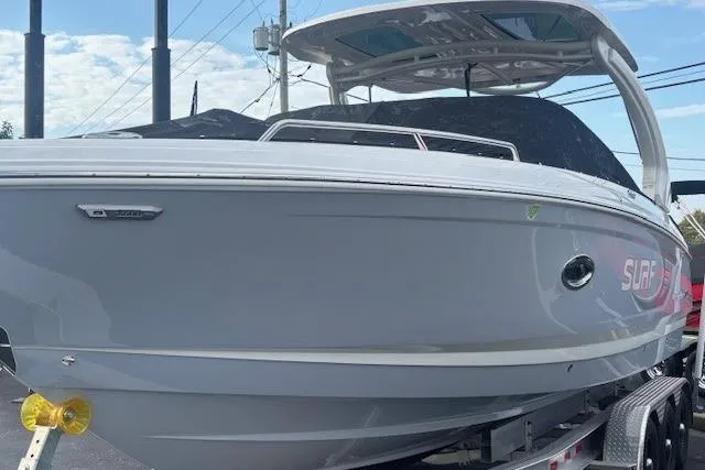 Slide: The Image of 2024 Chaparral 30 Surf boat with sleek design on a trailer, under a clear sky. - 47