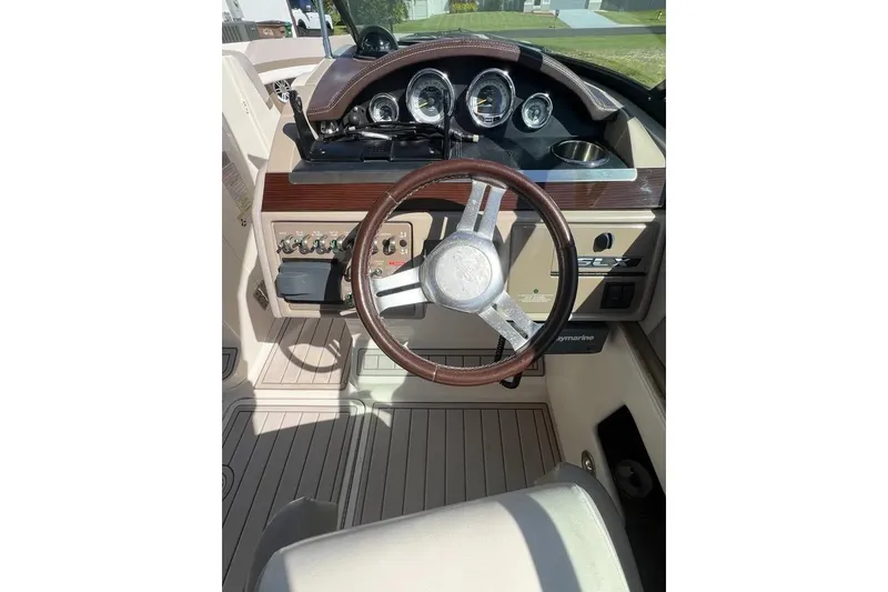 Slide: The Image of 2012 Sea Ray 250 SLX boat dashboard with steering wheel and gauges. - 11