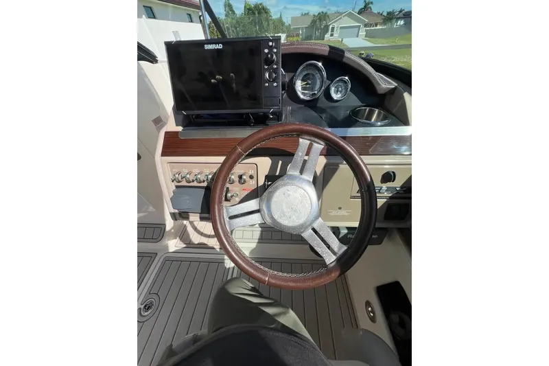 Slide: The Image of 2012 Sea Ray 250 SLX boat dashboard with steering wheel and navigation system. - 12