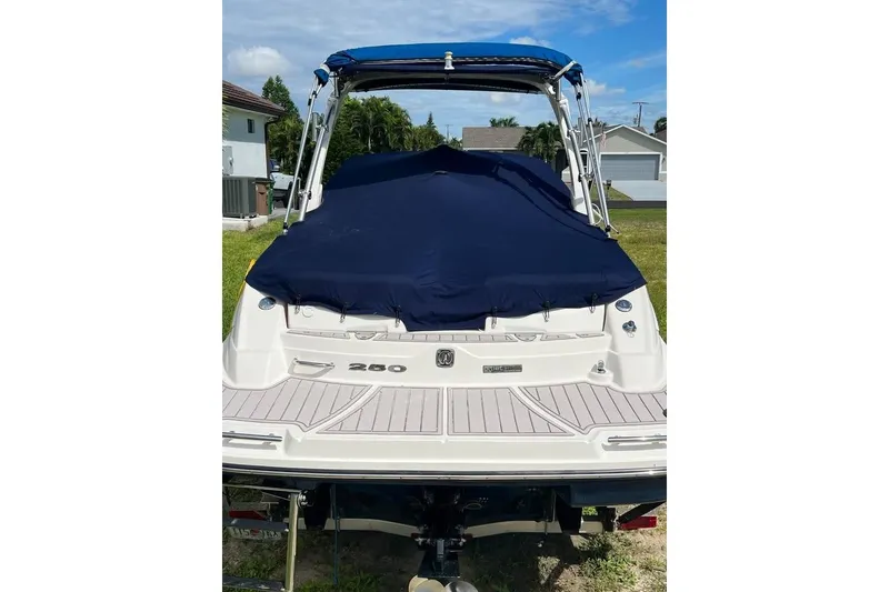 Slide: The Image of 2012 Sea Ray 250 SLX boat with blue cover, parked outdoors. - 18