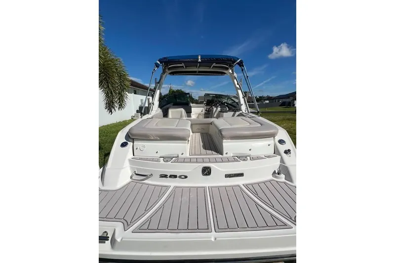 Slide: The Image of 2012 Sea Ray 250 SLX boat with spacious seating and sleek design under a clear blue sky. - 4