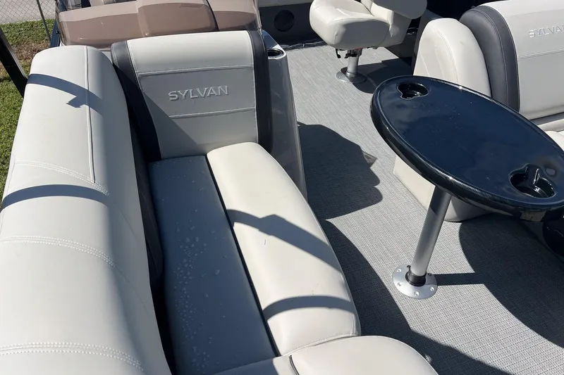 Slide: The Image of 2026 Sylvan MIRAGE 822 CLZ DH boat interior with beige seating and black table. - 6