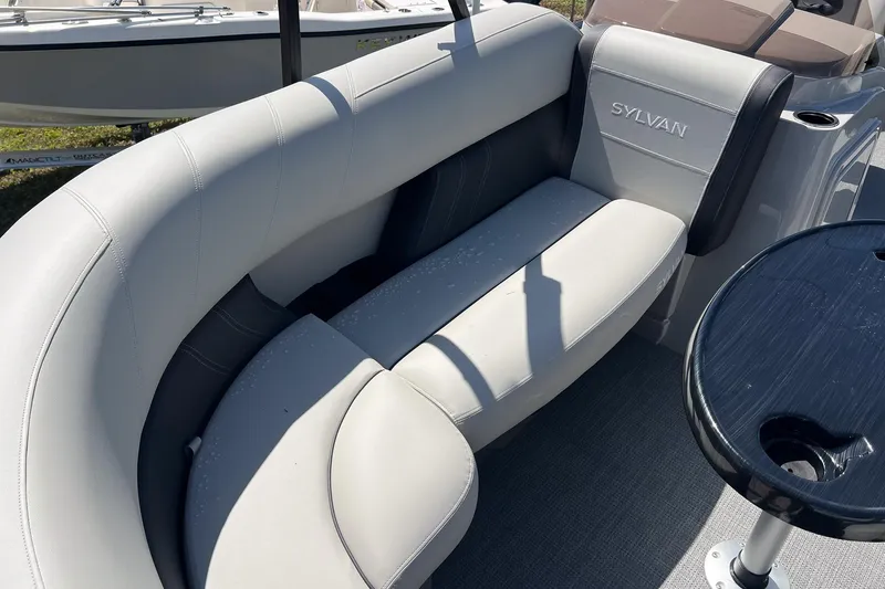 Slide: The Image of 2026 Sylvan MIRAGE 822 CLZ DH boat interior with gray seating and table. - 8