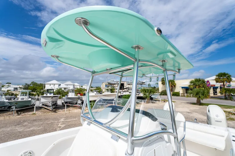 Slide: The Image of 2019 Twin Vee 240 GFX CC boat with teal T-top, parked in a marina under blue skies. - 15