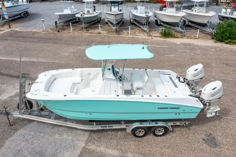 Slide: The Image of 2019 Twin Vee 240 GFX CC boat on trailer, featuring dual Suzuki engines. - 2