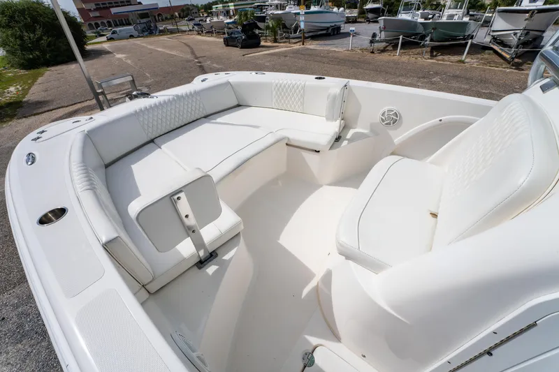 Slide: The Image of 2019 Twin Vee 240 GFX CC boat interior with white cushioned seating and cup holders. - 21