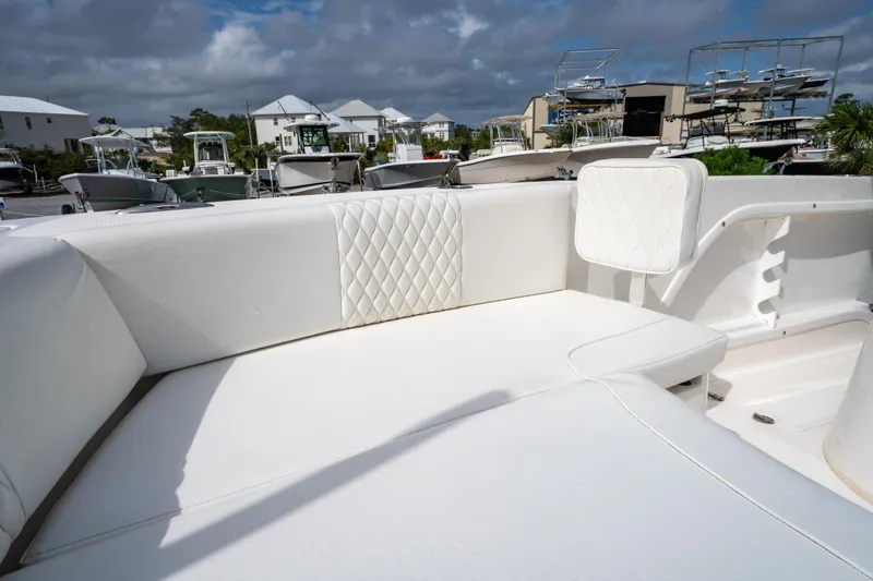 Slide: The Image of 2019 Twin Vee 240 GFX CC boat with white cushioned seating in a marina setting. - 31
