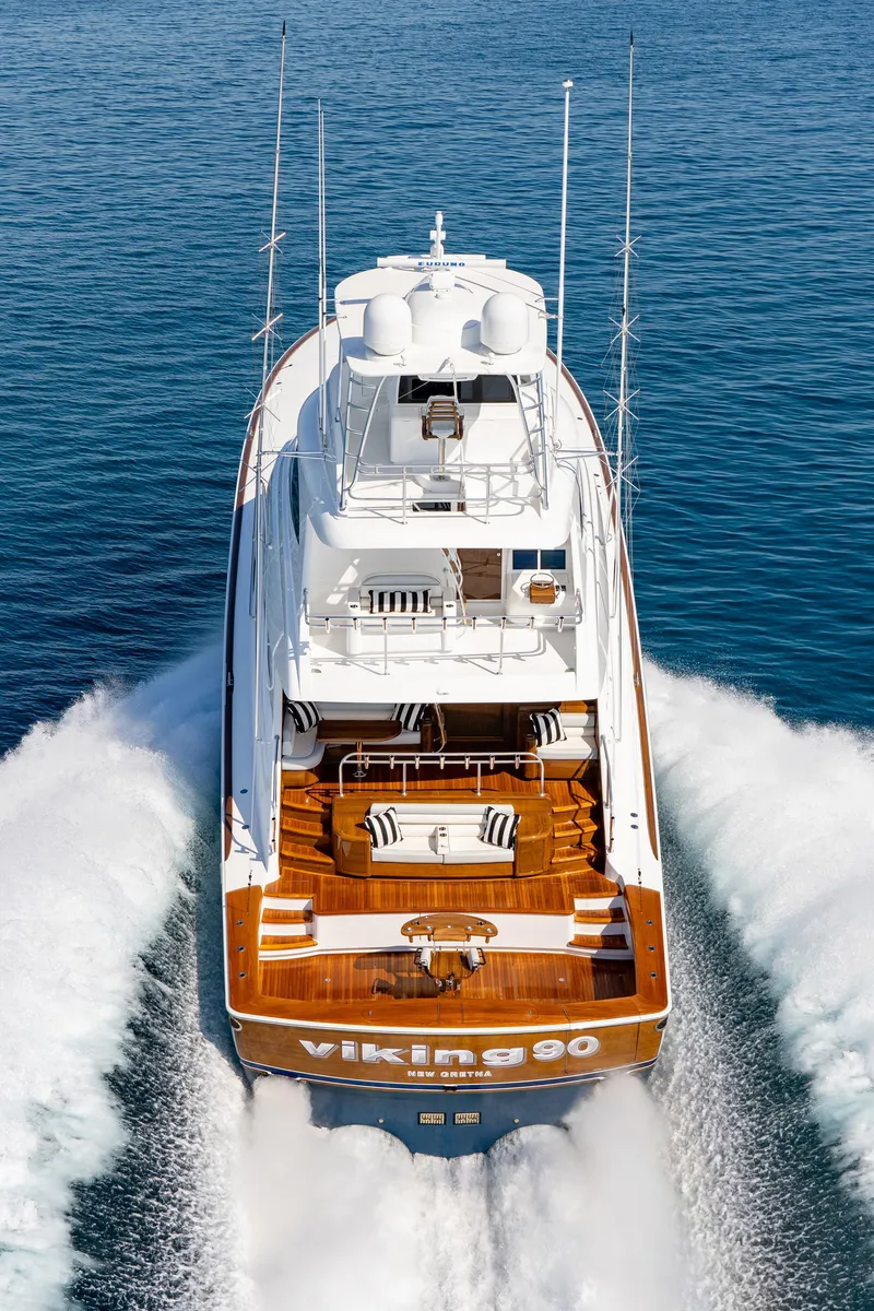 Slide: The Image of 2025 Viking 90 Convertible yacht cruising on open water, aerial view. - 2