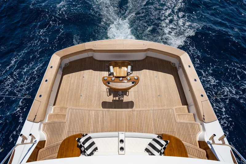Slide: The Image of 2025 Viking 90 Convertible yacht deck with teak flooring, cruising on open sea. - 5