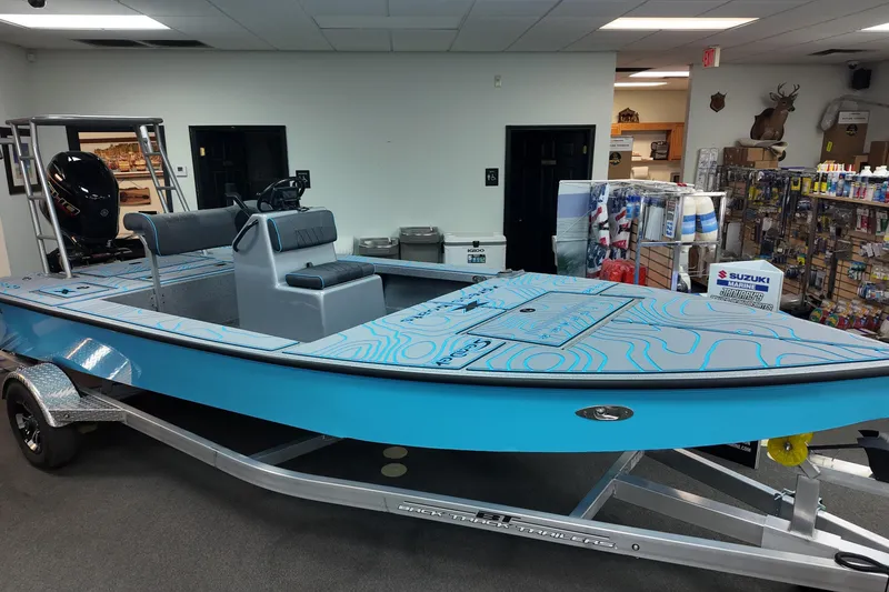 Slide: The Image of 2026 Xpress Skiff 185 boat in showroom, featuring blue design and modern seating. - 1