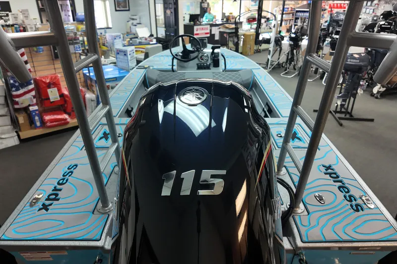 Slide: The Image of 2026 Xpress Skiff 185 boat with 115 horsepower engine in showroom display. - 19