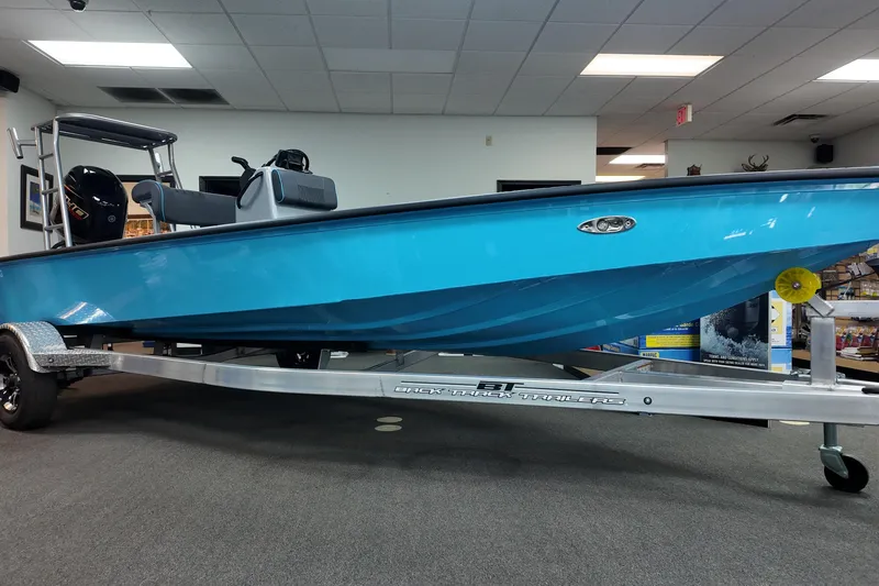Slide: The Image of 2026 Xpress Skiff 185 in showroom, vibrant blue hull on trailer. - 4