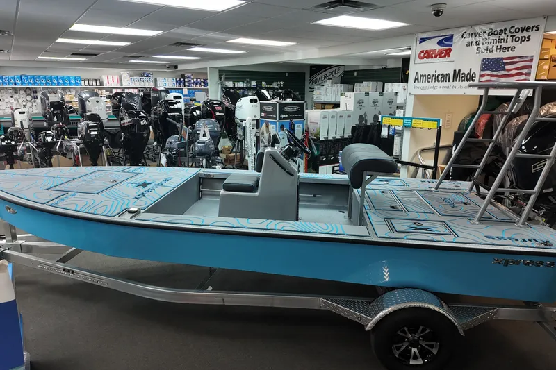 Slide: The Image of 2026 Xpress Skiff 185 boat displayed in a showroom with various outboard motors. - 5