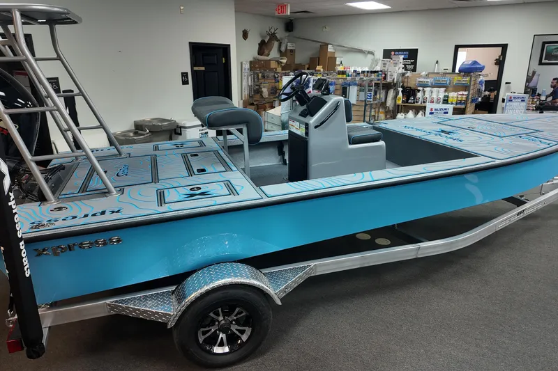 Slide: The Image of 2026 Xpress Skiff 185 in showroom, featuring blue design and modern seating. - 6