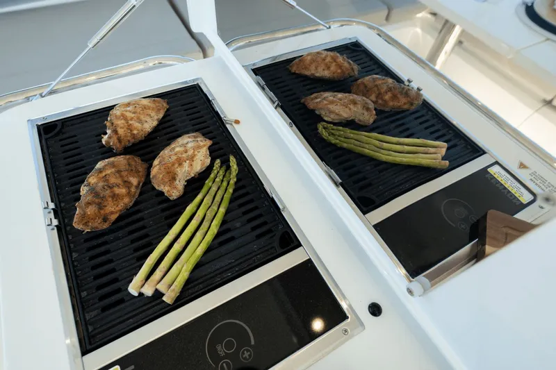 Slide: The Image of A grill on a boat with chicken and asparagus. - 39
