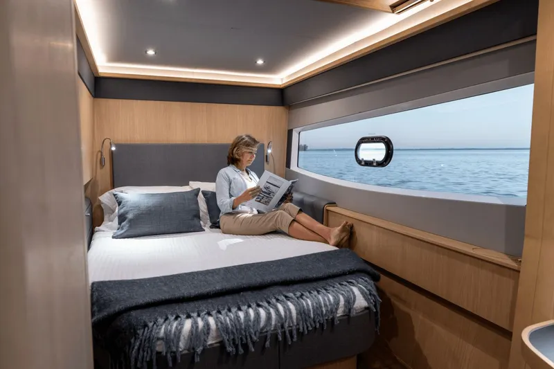 Slide: The Image of A woman reads in a cozy cabin with a large window overlooking the sea. - 16