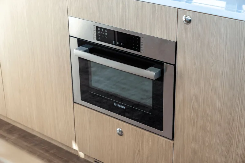 Slide: The Image of A modern Bosch oven is integrated into a sleek wooden cabinet. - 45