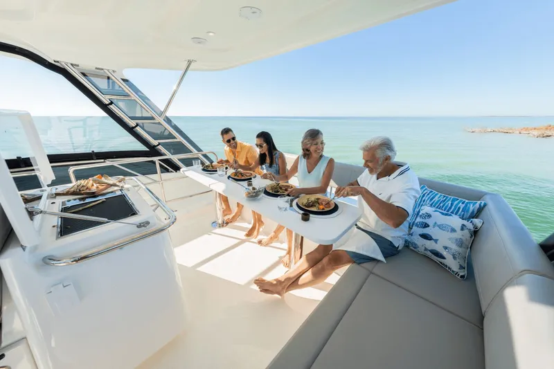 Slide: The Image of Four people enjoying a meal on a modern boat with a sea view. - 28