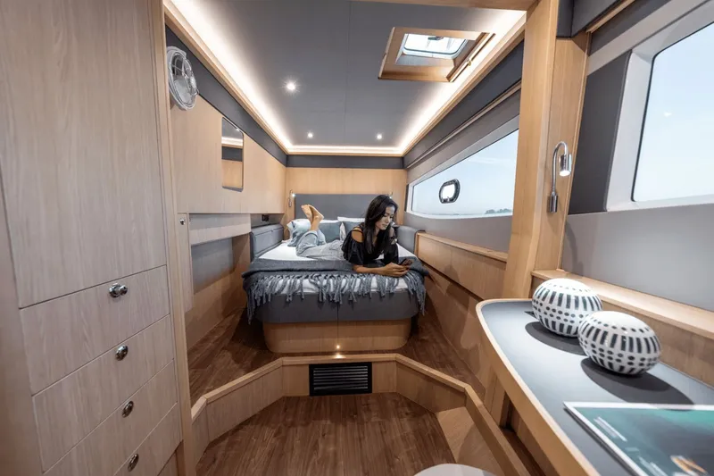 Slide: The Image of A modern cabin with wood paneling, a large bed, and windows overlooking the water. - 18