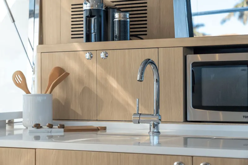 Slide: The Image of Modern kitchen on a 2027 Aquila A42Y with wooden cabinets, faucet, and microwave. - 41