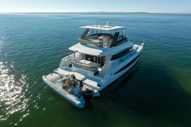 Slide: The Image of The 2027 Aquila A42Y is a luxurious motor yacht on calm waters with a spacious deck. - 9