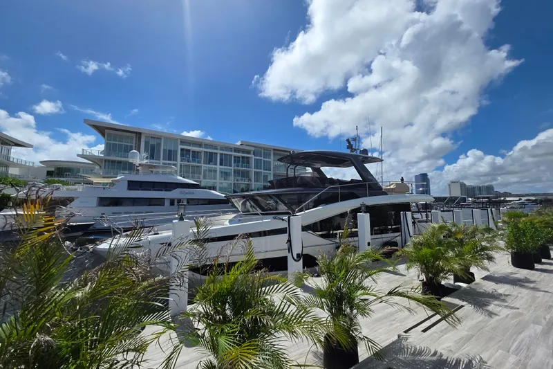 Slide: The Image of Luxurious 2022 Prestige X70 yacht docked at a marina under a bright blue sky. - 1