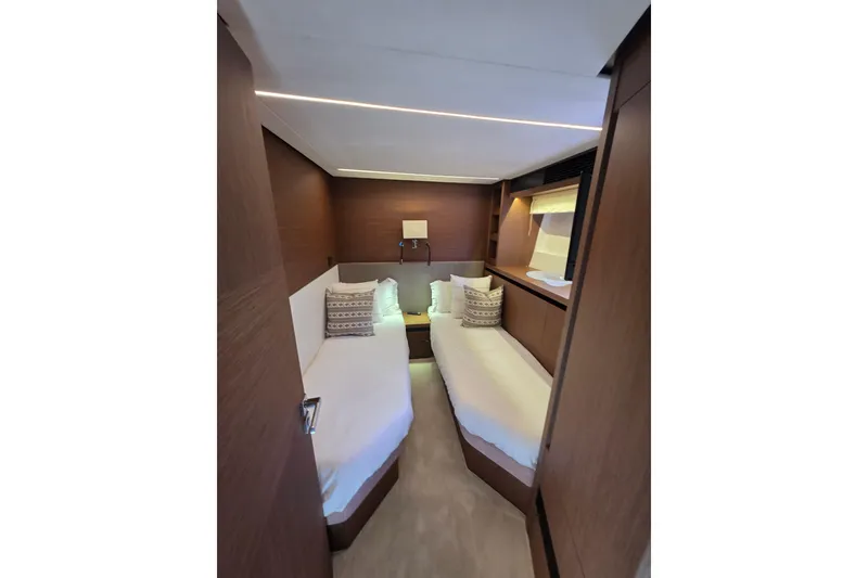 Slide: The Image of Luxurious twin cabin interior of 2022 Prestige X70 yacht, featuring elegant wood finishes. - 16