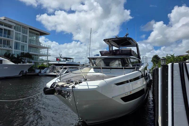Slide: The Image of Luxury 2022 Prestige X70 yacht docked by modern waterfront building under blue sky. - 2