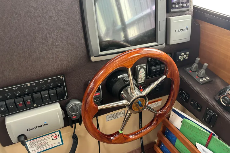 Slide: The Image of 2013 Cutwater C-28 helm with Garmin navigation, wooden steering wheel, and control panel. - 11