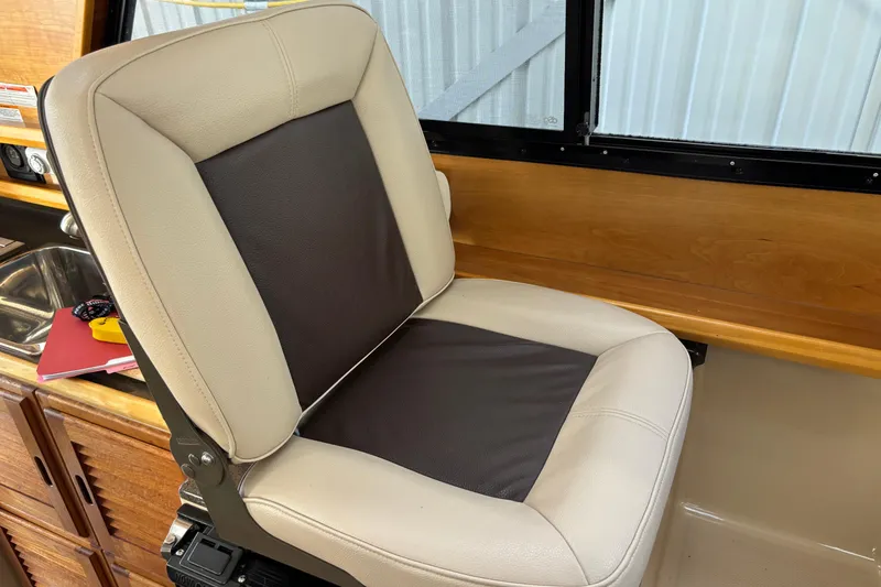 Slide: The Image of Captain's chair in 2013 Cutwater C-28 boat interior, near wooden cabinetry and window. - 14