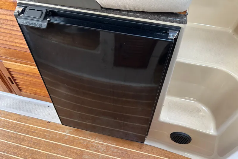 Slide: The Image of 2013 Cutwater C-28 boat interior with Nova Kool refrigerator and wooden flooring. - 16