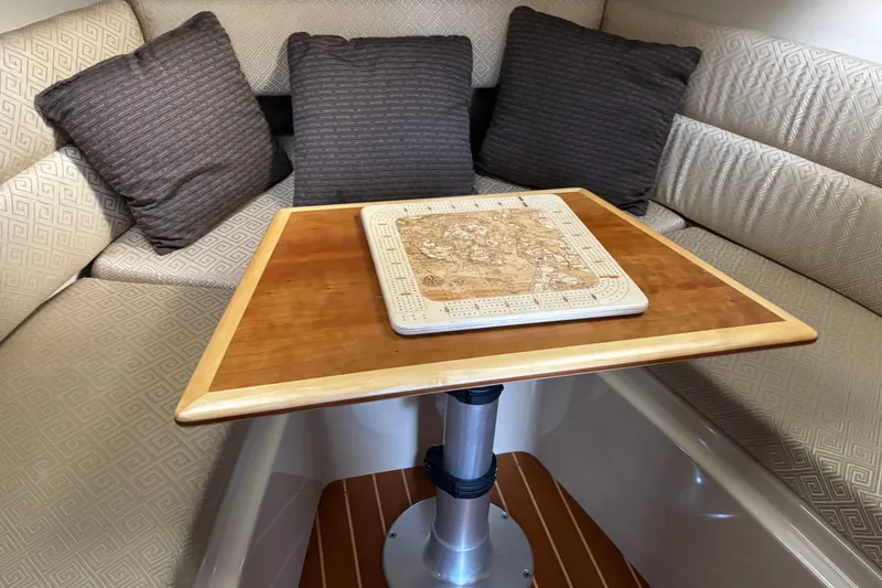 Slide: The Image of Interior of 2013 Cutwater C-28 boat with cushioned seating and wooden table. - 17