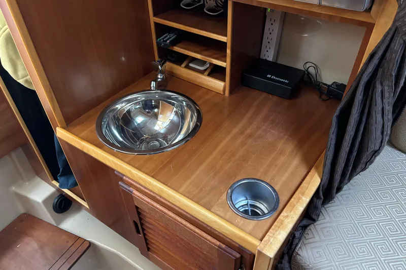 Slide: The Image of 2013 Cutwater C-28 interior with wooden countertop, sink, and storage shelves. - 18