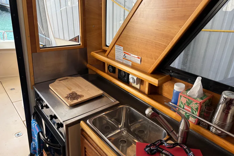 Slide: The Image of 2013 Cutwater C-28 boat kitchen with stove, sink, and wooden cutting board. - 19