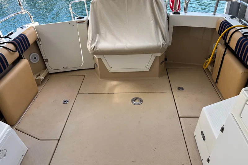 Slide: The Image of 2013 Cutwater C-28 boat deck with seating, beige flooring, and water view. - 2