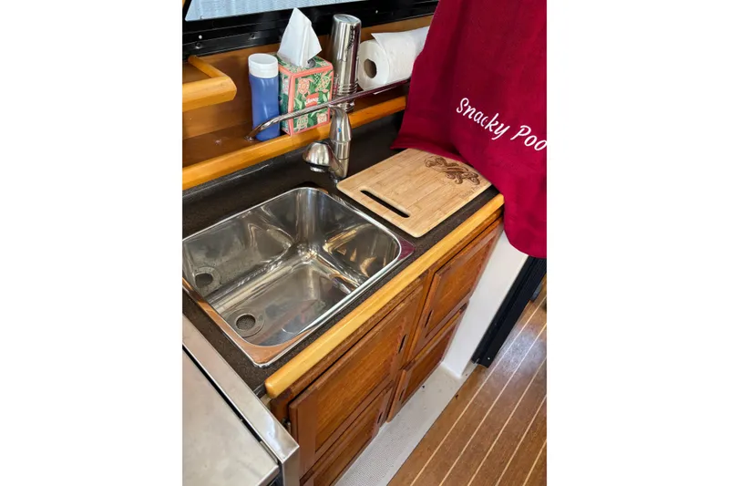 Slide: The Image of 2013 Cutwater C-28 boat kitchen sink with wooden cabinets and countertop accessories. - 7