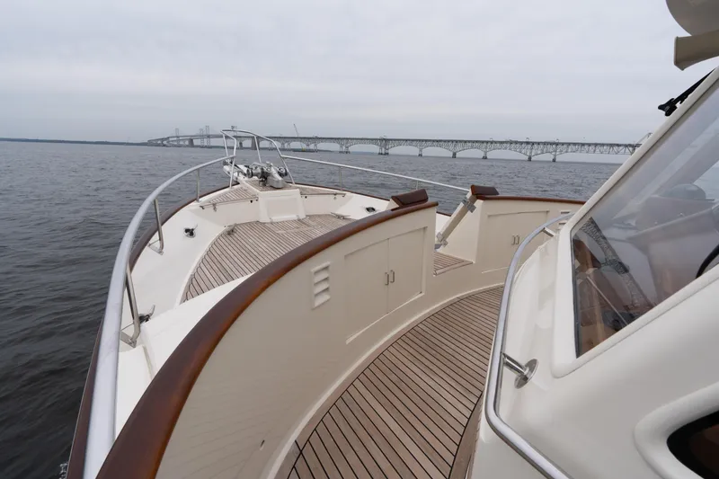 Slide: The Image of Luxury Fleming 55 yacht cruising near a bridge, showcasing elegant deck design, 2007 model. - 18