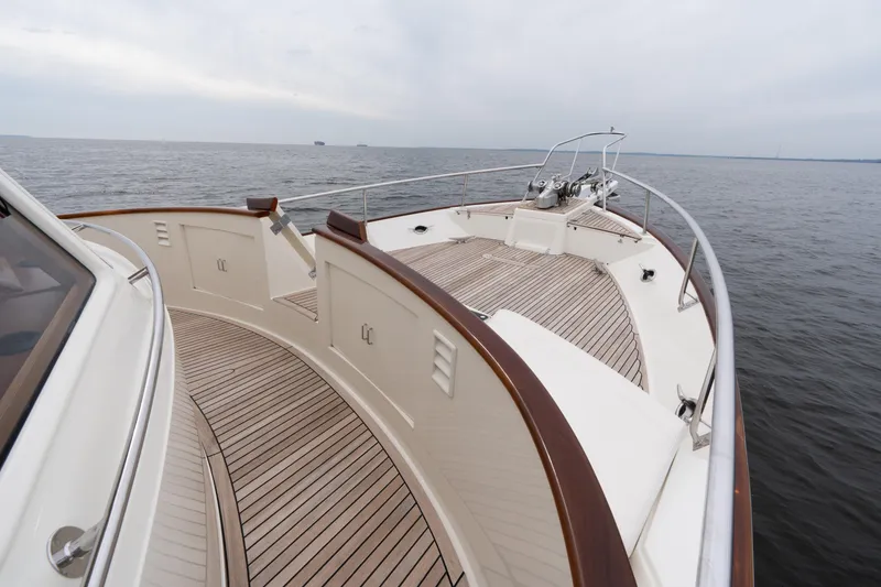Slide: The Image of 2007 Fleming 55 yacht deck with wooden flooring, cruising on open water. - 26