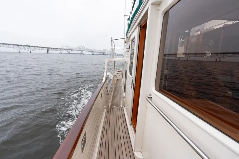 Slide: The Image of 2007 Fleming 55 yacht cruising near a bridge on a calm waterway. - 27