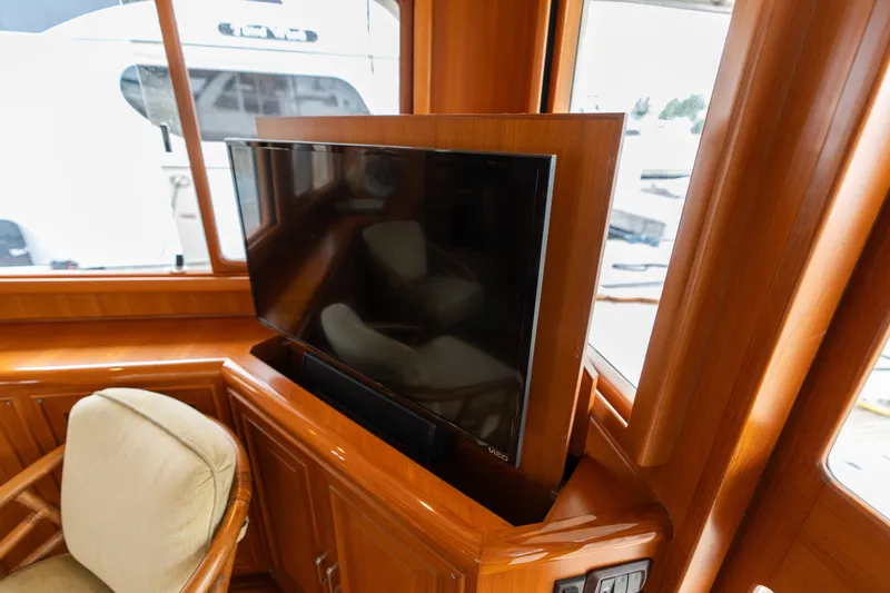 Slide: The Image of Luxurious 2007 Fleming 55 yacht interior with built-in TV and wooden cabinetry. - 38