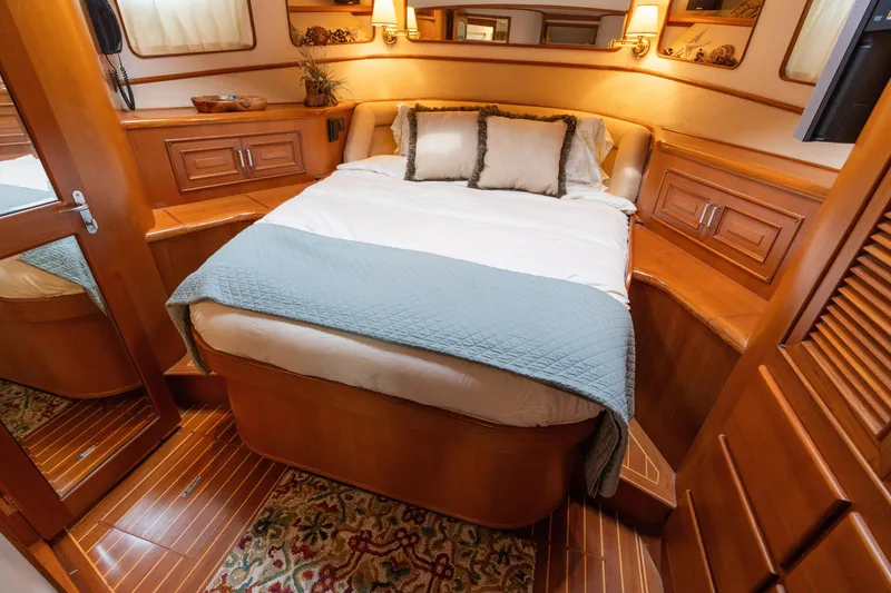 Slide: The Image of Luxurious 2007 Fleming 55 yacht bedroom with elegant wood finish and cozy bedding. - 48