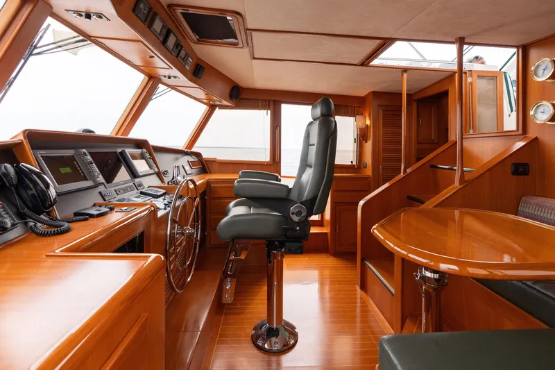 Slide: The Image of Cozy dining nook on 2007 Fleming 55 yacht with wooden table and cushioned seating. - 64