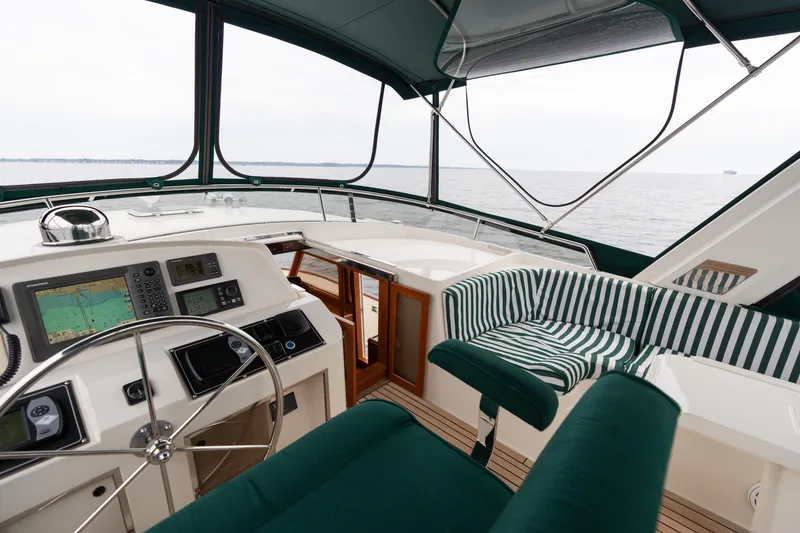 Slide: The Image of 2007 Fleming 55 yacht helm with navigation equipment, steering wheel, and ocean view. - 74