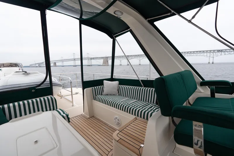 Slide: The Image of Luxurious 2007 Fleming 55 yacht interior with striped seating, table, and scenic bridge view. - 78