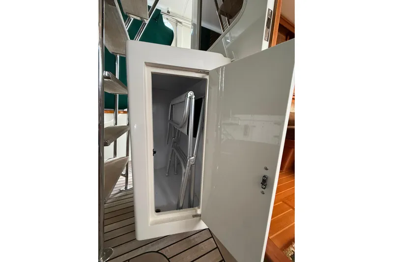Slide: The Image of Storage compartment on a 2007 Fleming 55 yacht with folding chairs inside. - 8