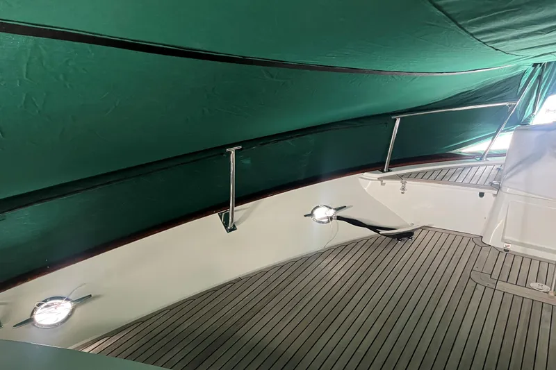 Slide: The Image of 2007 Fleming 55 yacht with green cover docked at marina. - 99