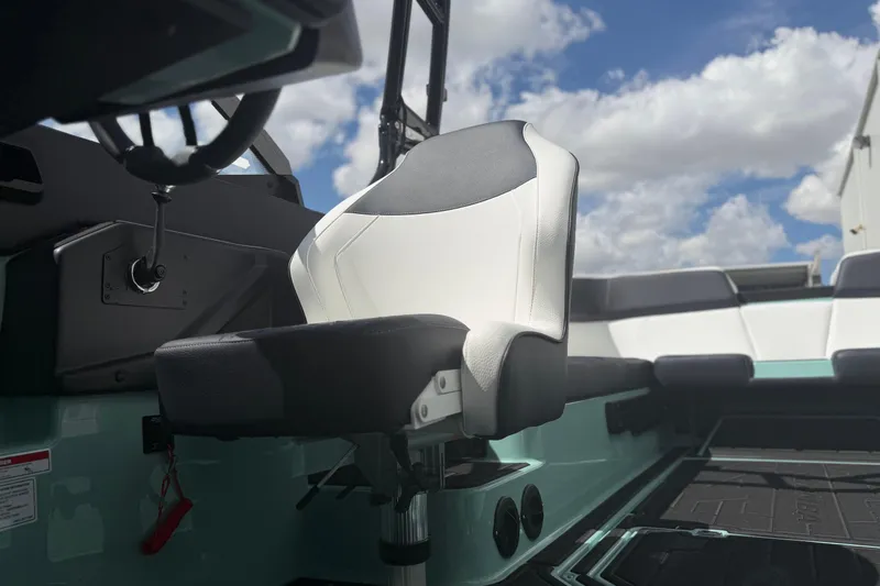 Slide: The Image of 2025 Moomba Tykon boat interior with modern seating and dashboard under a blue sky. - 18