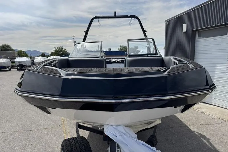 Slide: The Image of 2025 Moomba Tykon boat on trailer, sleek design, parked outdoors. - 4