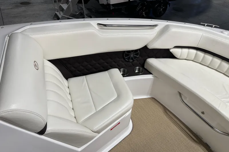 Slide: The Image of Luxurious white seating in a 2012 Cobalt A25 boat, featuring quilted accents and cup holders. - 20