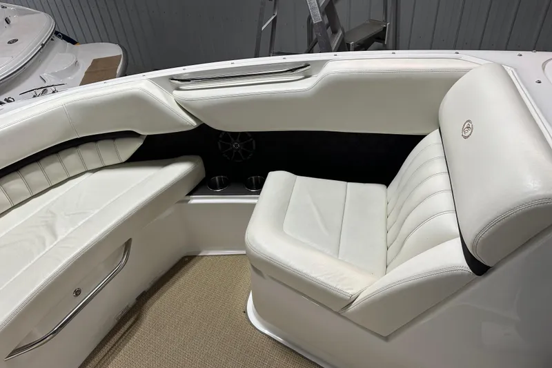 Slide: The Image of 2012 Cobalt A25 boat interior with white leather seating and cup holders. - 21
